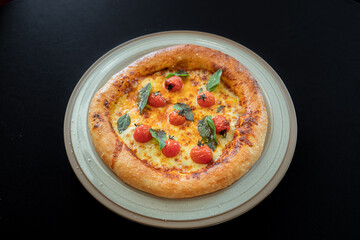 Savory Margherita Pizza: A vibrant margherita pizza, boasting a perfectly baked crust, is adorned with fresh basil leaves and ripe cherry tomatoes, resting elegantly on a rustic plate.