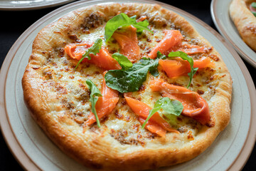 Artisan Pizza Delight: A tantalizing artisan pizza, boasting a golden crust, is artfully arranged on a rustic plate, adorned with fresh toppings.