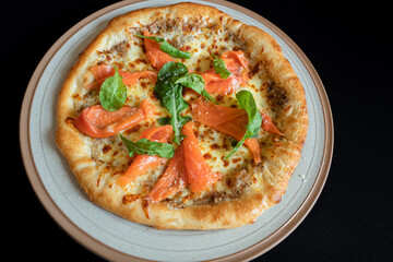 Salmon Pizza Delight: A mouthwatering close-up captures a gourmet pizza topped with fresh salmon,...
