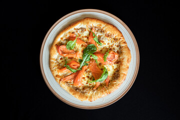 Gourmet Pizza Delight: A mouthwatering gourmet pizza, expertly crafted and brimming with fresh ingredients, sits invitingly on a plate, a culinary masterpiece perfect for a flavorful experience.