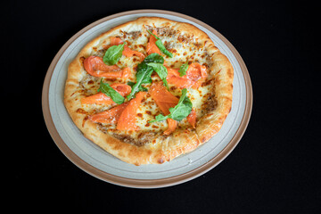 Savory Delight: A culinary creation, a close-up shot of a gourmet pizza, artfully arranged on a rustic plate. The pizza boasts a perfectly baked crust and an enticing medley of fresh ingredients.