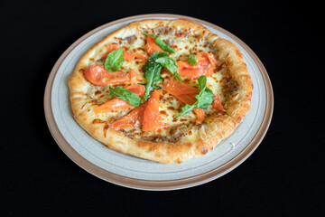 Gourmet Pizza Delight: A freshly baked gourmet pizza, adorned with succulent smoked salmon, vibrant basil leaves, and a medley of culinary delights.