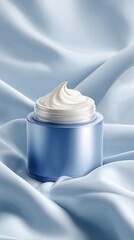 Blue jar of creamy face moisturizer on a light blue silk fabric