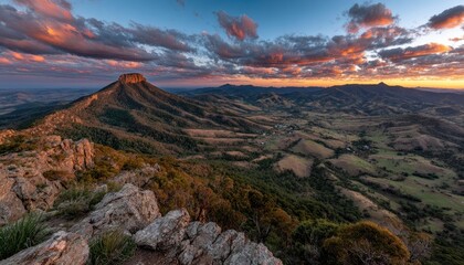 Mountaintop vista at sunset. Dramatic clouds, colorful sky, rugged peaks, valley below