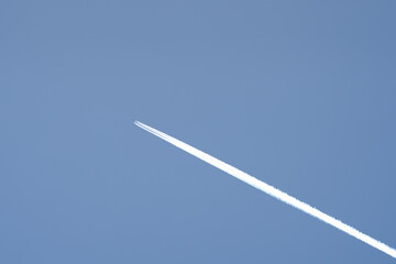 twin engined jet liner aircraft with contrails, in flight at high altitude, clear blue sky