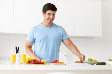 Handsome young healthy man preparing healthy vegetable food
