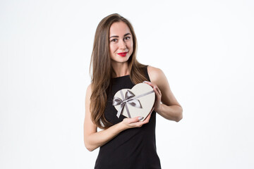 Beautiful woman with a heart-shaped gift in her hands. A gift for a romantic date. Isolated on white