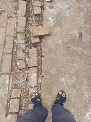 A person standing on two different ground textures