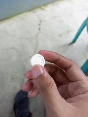 Hand Holding a Single White Candy