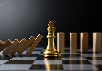 A golden chess king stands resiliently on a chessboard as a line of wooden dominoes falls towards it, symbolizing strategic stability amidst challenges.