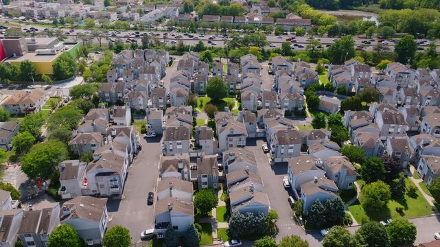 Aerial drone video of a wide suburban residential community with rows of houses, streets, and greenery, captured in ProRes 422HQ