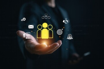 Businessman offering glowing team management icon with digital strategy elements,concept of HR leadership,organizational growth,networking and professional development