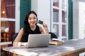 Smiling freelancer doing online shopping with credit card