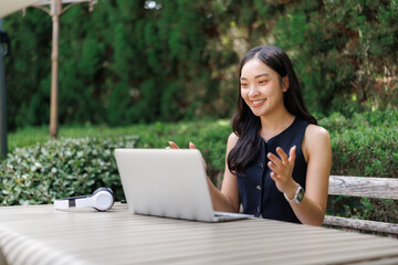Young businesswoman video calling using laptop in park