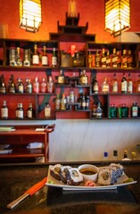 Sushi plate with chopsticks in a cozy restaurant setting.