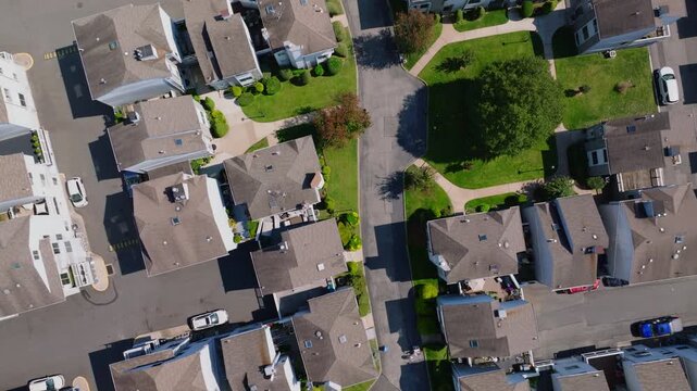 Aerial drone video of a wide suburban residential community with rows of houses, streets, and greenery, captured in ProRes 422HQ