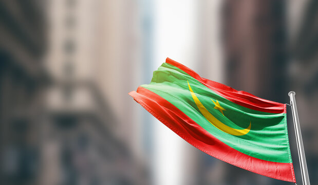 Mauritania national flag waving on street. A beautiful with mast with blur buildings. Mauritania national flag for independence day. - Powered by Adobe