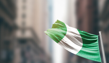 Nigeria national flag waving on street. A beautiful with mast with blur buildings. Nigeria national...