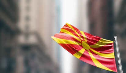 North Macedonia national flag waving on street. A beautiful with mast with blur buildings. North Macedonia national flag for independence day.