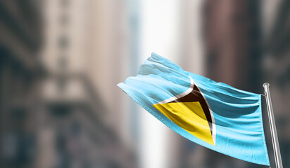 Saint Lucia national flag waving on street. A beautiful with mast with blur buildings. Saint Lucia...