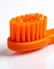 Close-up of an orange toothbrush head with toothpaste