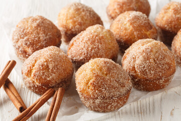 Donut muffins are a super soft buttery treats taste just like an old fashioned donut rolled in cinnamon and sugar close-up on the wooden table. Horizontal