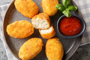 Breaded and fried chicken Croquettes served tomato sauce close-up in a plate on the table. Horizontal top view from above