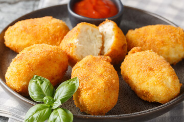 Spanish Croquettes chicken in a creamy bechamel sauce served with tomato sauce close-up in a plate on the table. Horizontal