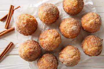 Donut muffins are a super soft buttery treats taste just like an old fashioned donut rolled in cinnamon and sugar close-up on the wooden table. Horizontal top view from above