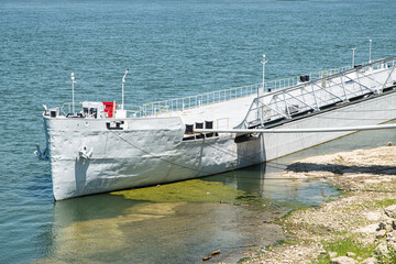 Decommissioned river vessel serving as stationary pontoon between shore and moored passenger ship