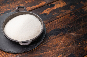 Bright and clean granulated sugar, an essential ingredient for delicious treats and drinks. wooden background. top view