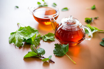 Natural tea from currant leaves and mint on brown background