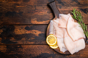 Freshly caught raw squid with glistening skin, perfect for grilling or frying to create...