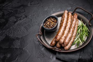 Juicy grilled sausage sizzling on the barbecue, perfect for summer cookouts and outdoor gatherings. black background. top view