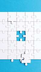 Unfinished white jigsaw puzzle on blue