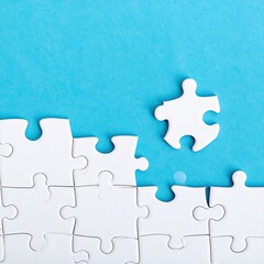 Obraz premium Unfinished white puzzle on turquoise