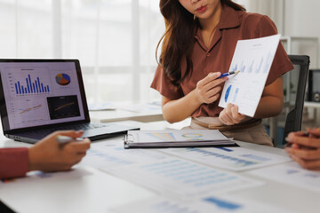 Businesswomen analyzing financial charts and graphs during meeting