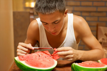 Teenager Consuming Organic Watermelon During a Balanced Indoor Meal.