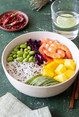 Hawaiian poke bowl with rice, shrimp, red cabbage, radish, edamame, and mango. Healthy eating. Diet.
