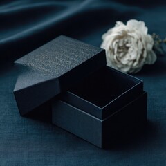 Open dark-blue gift box, textured, with cream rose
