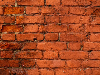 Old red brick wall. The texture of weathered grungy brickwork. Masonry background.