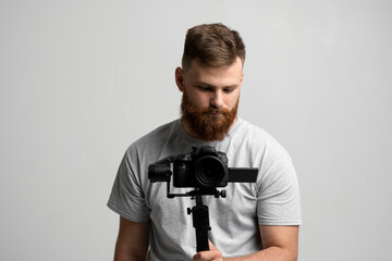 Bearded man holding professional camera on stabilizer for filmmaking and video work