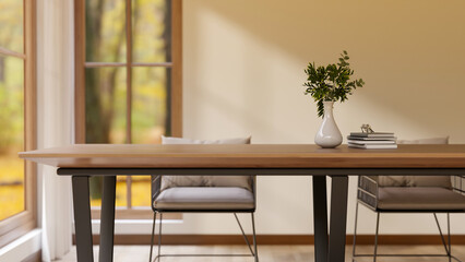 Wooden table and metal armchairs with cushions on parquet floor and garden scenery outside the room.