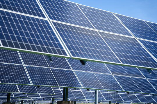 Angled rows of photovoltaic solar panels mounted on steel supports, designed for efficient outdoor renewable energy generation across farms, fields, and industrial spaces
