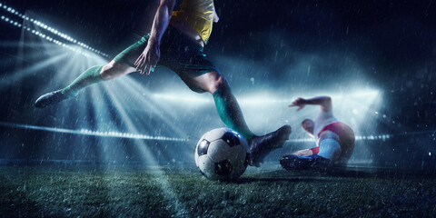 International tournament. Two competitive football players in motion try to keep defense in wet...