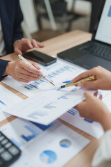Businesswomen analyzing financial charts and data in office meeting