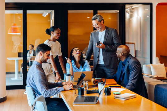 Business team brainstorms ideas during a lively meeting in a bright office