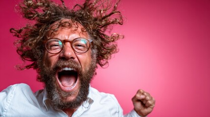 A joyful man with wild curly hair, wearing glasses, exuberantly expresses his excitement and happiness, set against a vibrant pink background that radiates energy and fun.