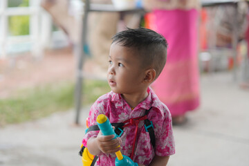 Children playing Songkran use water guns.
