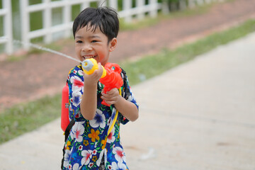 Children playing Songkran use water guns.